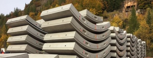 Aufeinandergestapelte Faserbetontübbingen sind im Freien zu sehen.